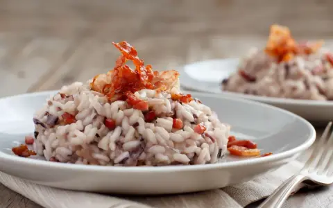 Risotto cremoso con radicchio e pancetta croccante, un classico da provare se ti chiedi cosa mangiare a Treviso.