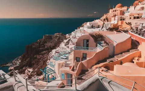 Case bianche e blu aggrappate alla scogliera di Santorini, un sogno per chi cerca cosa fare a Santorini in 7 giorni.