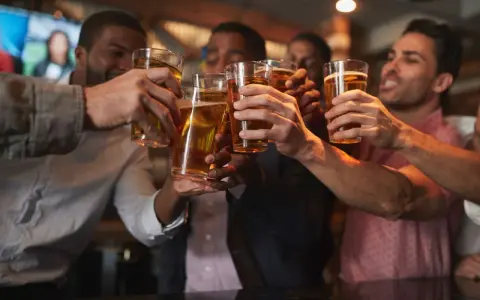 Amici brindano con birra in un locale, un brindisi per l'addio al celibato.