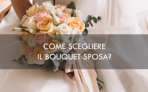 Un bouquet sposa elegantissimo con rose pesca, rosa e bianche, tenuto da una sposa.