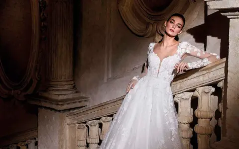 Modella con abiti da sposa per sembrare più alte, posa su una scala di pietra antica.