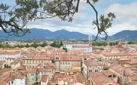 Panoramica di Lucca con tetti rossi e montagne sullo sfondo. Ideale per scoprire cosa vedere in un giorno.