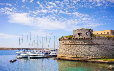 Porto di Gallipoli con castello e barche a vela. Un luogo incantevole per scoprire cosa fare a Gallipoli.