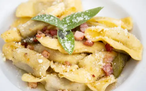 Casoncelli alla bergamasca, un classico su cosa mangiare a Bergamo, con pancetta, salvia e abbondante parmigiano.