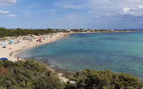 Spiaggia di Punta Prosciutto, Salento. Acque cristalline e sabbia dorata, ideale per una vacanza. Prezzi accessibili per godersi il mare.