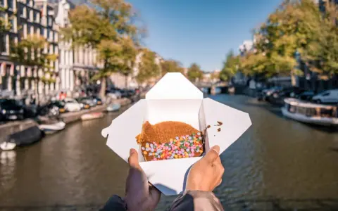 Un delizioso stroopwafel con zuccherini colorati, perfetto da gustare passeggiando lungo i canali di Amsterdam. Ecco cosa mangiare ad Amsterdam!