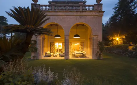 Villa Carrara a Genova, con portico illuminato e giardino serale.
