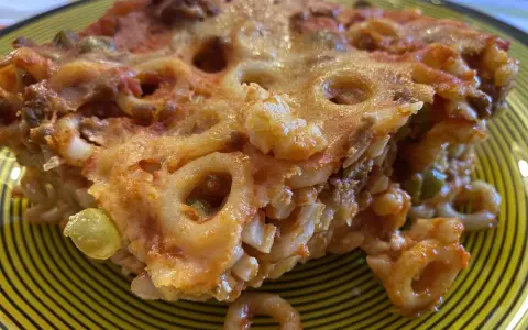 Un pezzo di pasta al forno con ragù e piselli, un'idea gustosa per cosa mangiare a Palermo.