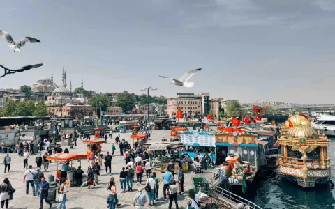 Un vivace mercato sul lungomare di Istanbul, con bancarelle di cibo, barche e la moschea sullo sfondo. Un momento perfetto per capire quando andare a Istanbul.