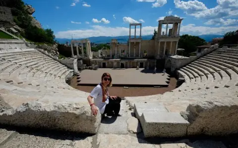 Donna sorride nell'antico teatro romano, un must per chi visita Plovdiv cosa vedere.