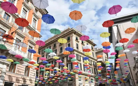 Un cielo di ombrelli colorati sopra i palazzi di Genova. Un'installazione suggestiva, perfetta per scoprire cosa vedere a Genova in 3 giorni.