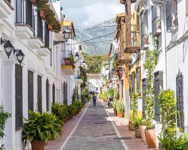 Un vicolo pittoresco con case bianche e colorate, balconi fioriti e piante in vaso. Un assaggio di cosa vedere a Marbella, tra fascino e tradizione.