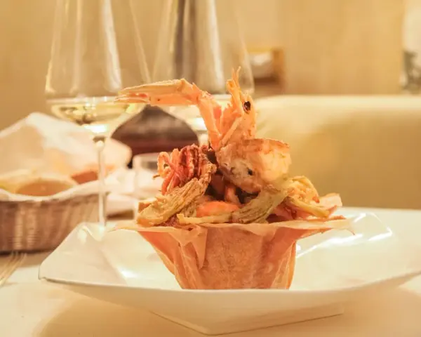 Frittura di pesce croccante, un'ottima idea per dove mangiare a Padova spendendo poco. Accompagnata da vino bianco e pane fresco.