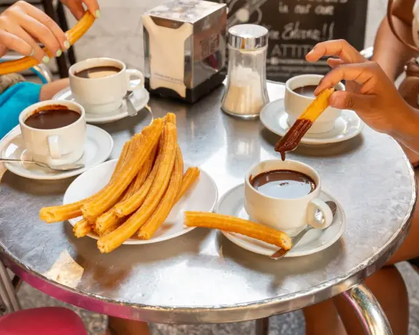 Assaporare i churros con cioccolata calda è un must per sapere cosa mangiare a Madrid. Un'esperienza golosa da condividere.