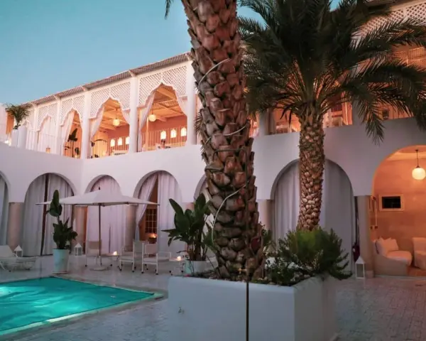 Un'oasi di pace per sapere dove dormire a Marrakech: piscina, palme e architettura moresca creano un'atmosfera magica.