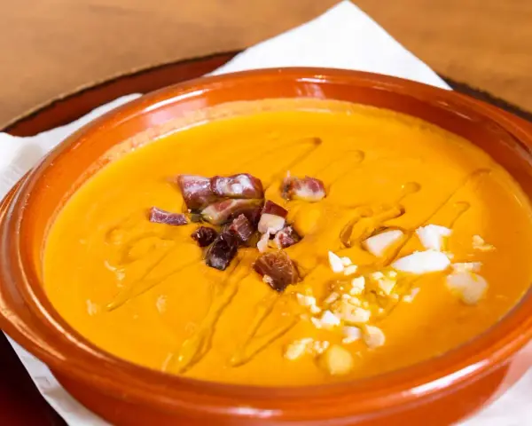 Gazpacho and salmorejo: ecco cosa mangiare a Siviglia per un'esperienza culinaria autentica. Gusta questa crema fredda con dadini di prosciutto e uovo sodo.