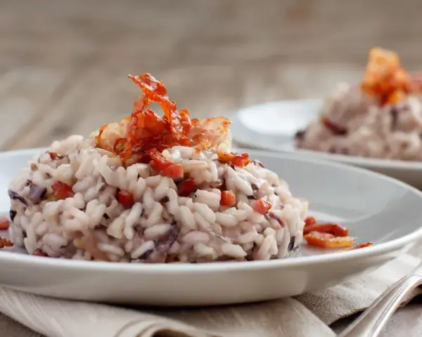 Risotto cremoso con radicchio e pancetta croccante, un classico da provare se ti chiedi cosa mangiare a Treviso.