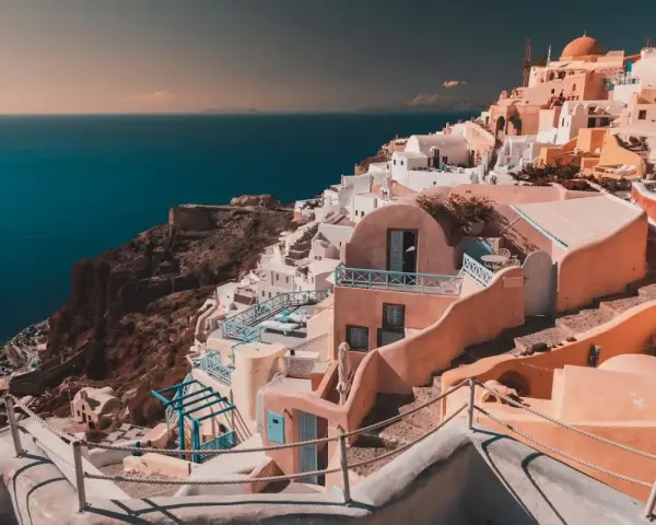 Case bianche e blu aggrappate alla scogliera di Santorini, un sogno per chi cerca cosa fare a Santorini in 7 giorni.
