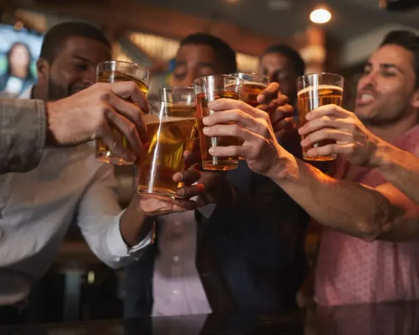 Amici brindano con birra in un locale, un brindisi per l'addio al celibato.