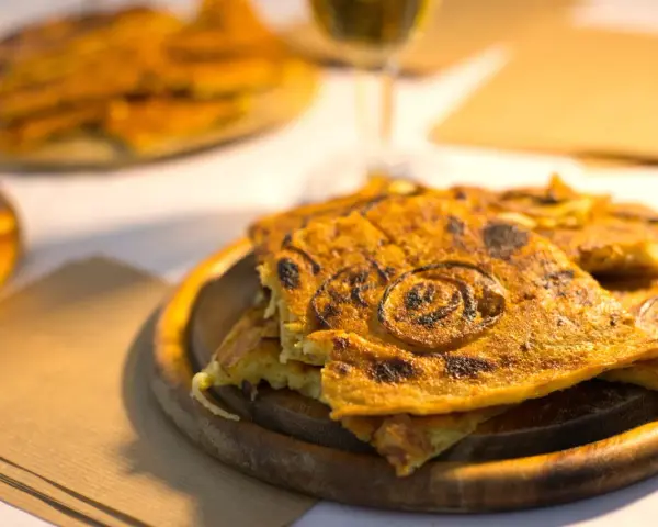 Farinata, una delizia da provare per scoprire cosa mangiare a Pisa. Croccante fuori e morbida dentro, con cipolle caramellate.