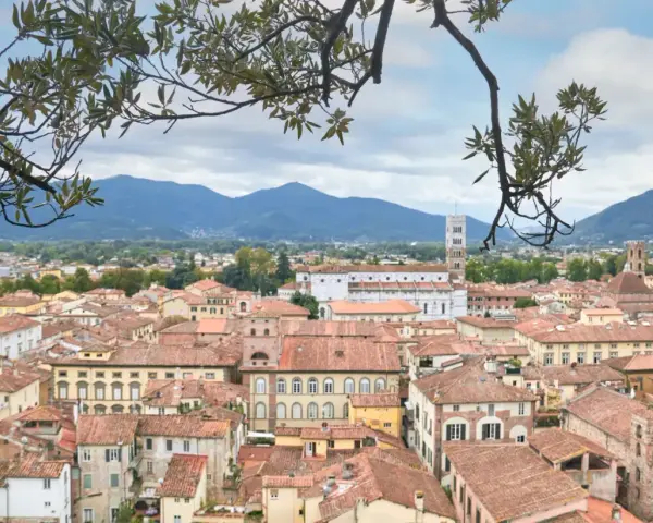 Panoramica di Lucca con tetti rossi e montagne sullo sfondo. Ideale per scoprire cosa vedere in un giorno.