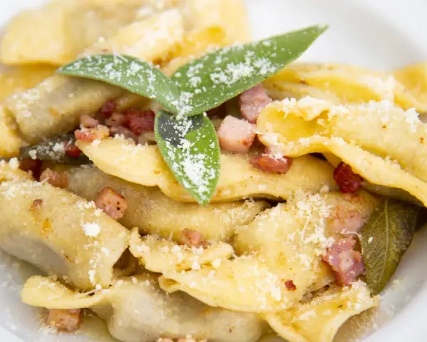 Casoncelli alla bergamasca, un classico su cosa mangiare a Bergamo, con pancetta, salvia e abbondante parmigiano.