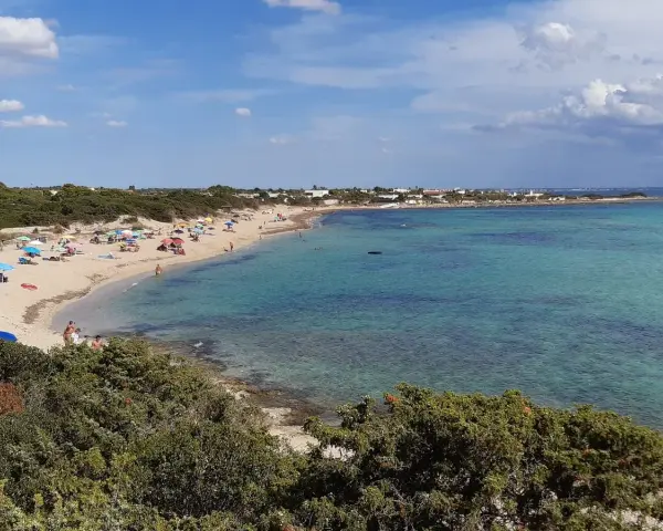 Spiaggia di Punta Prosciutto, Salento. Acque cristalline e sabbia dorata, ideale per una vacanza. Prezzi accessibili per godersi il mare.