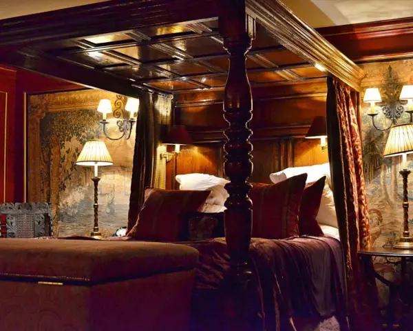 Lussuosa camera da letto con letto a baldacchino, arazzi storici e lampade eleganti. Un'idea di dove dormire a Edimburgo per un soggiorno da re.
