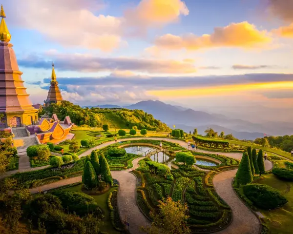 Templi dorati su una collina verdeggiante, con giardini curati e montagne all'orizzonte. Un luogo imperdibile tra le cose da vedere a Chiang Mai.