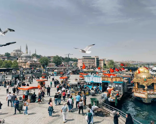 Un vivace mercato sul lungomare di Istanbul, con bancarelle di cibo, barche e la moschea sullo sfondo. Un momento perfetto per capire quando andare a Istanbul.