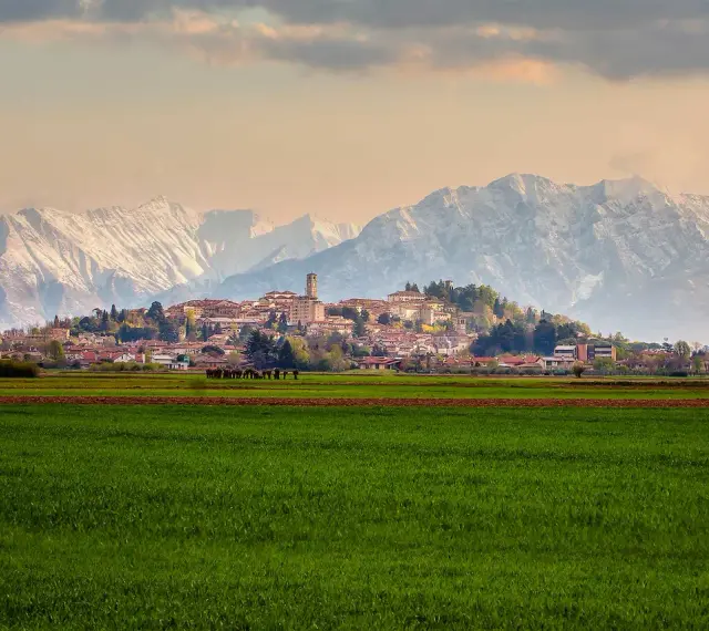 Campi verdi e montagne innevate incorniciano il borgo di San Daniele.