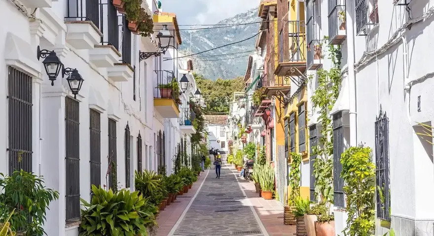 Un vicolo pittoresco con case bianche e colorate, balconi fioriti e piante in vaso. Un assaggio di cosa vedere a Marbella, tra fascino e tradizione.
