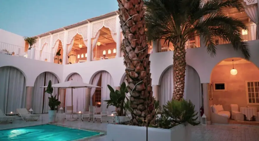 Un'oasi di pace per sapere dove dormire a Marrakech: piscina, palme e architettura moresca creano un'atmosfera magica.