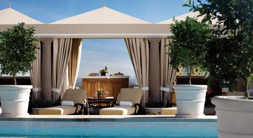 Rilassati in piscina a Los Angeles. Due lettini prendisole e alberi in vaso creano un'oasi perfetta per sapere dove dormire a Los Angeles.