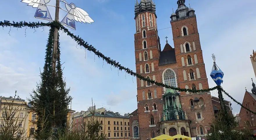 Mercatino natalizio a Cracovia, con la Basilica di Santa Maria in sottofondo. Perfetto per trovare dove dormire a Cracovia.