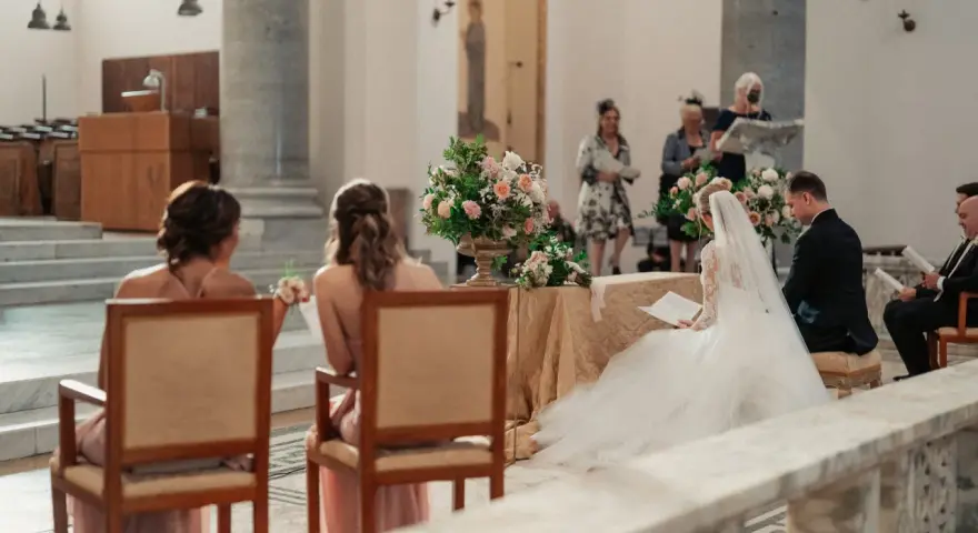 Sposi in chiesa, con la sposa in abito bianco e il velo. Si possono avere 6 testimoni di nozze, ma qui ne vediamo solo alcuni.