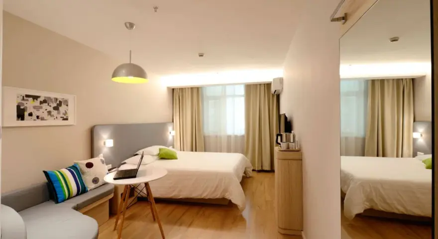 Camera accogliente con letto, divanetto e laptop, ideale per sapere dove alloggiare ad Amsterdam.