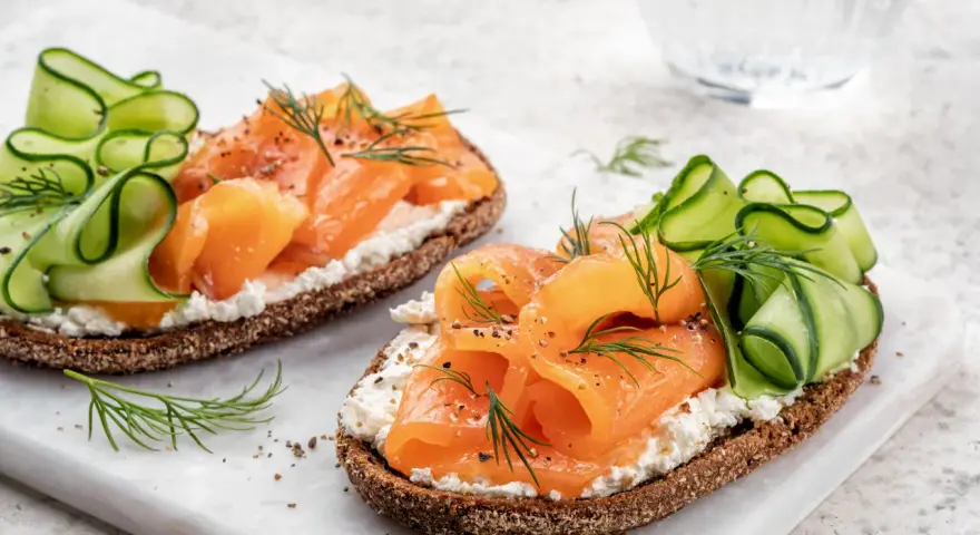 Smørrebrød con salmone affumicato, cetrioli e aneto. Un'idea su cosa mangiare a Copenaghen per un pranzo leggero e gustoso.