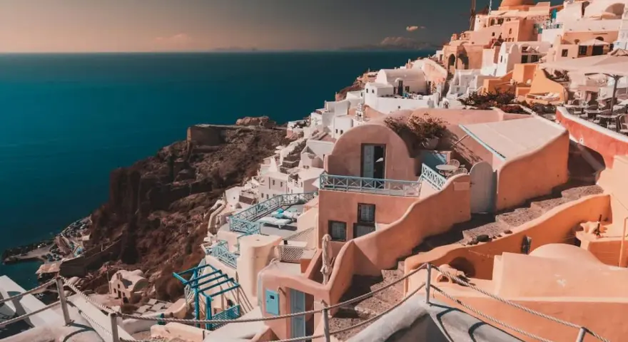 Case bianche e blu aggrappate alla scogliera di Santorini, un sogno per chi cerca cosa fare a Santorini in 7 giorni.