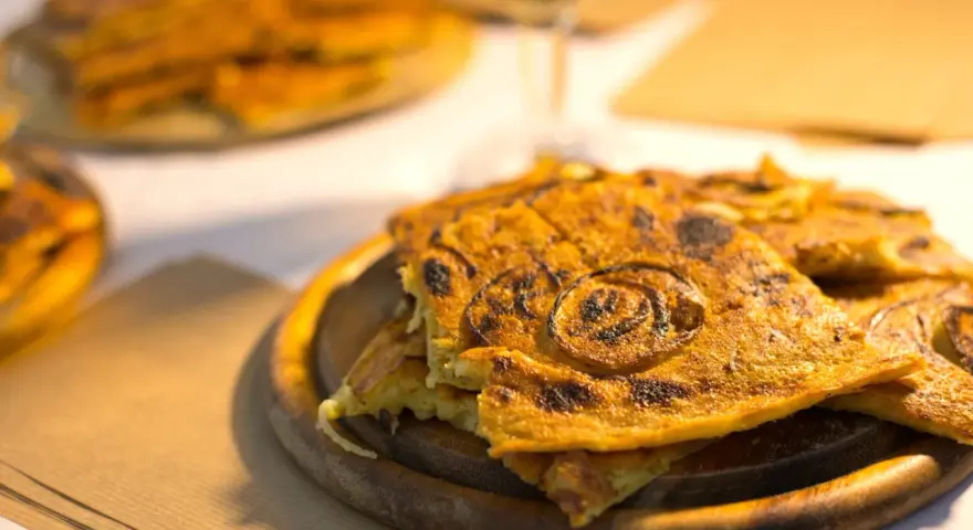 Farinata, una delizia da provare per scoprire cosa mangiare a Pisa. Croccante fuori e morbida dentro, con cipolle caramellate.