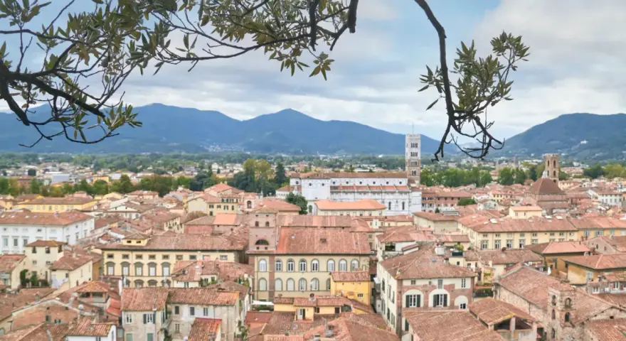 Panoramica di Lucca con tetti rossi e montagne sullo sfondo. Ideale per scoprire cosa vedere in un giorno.