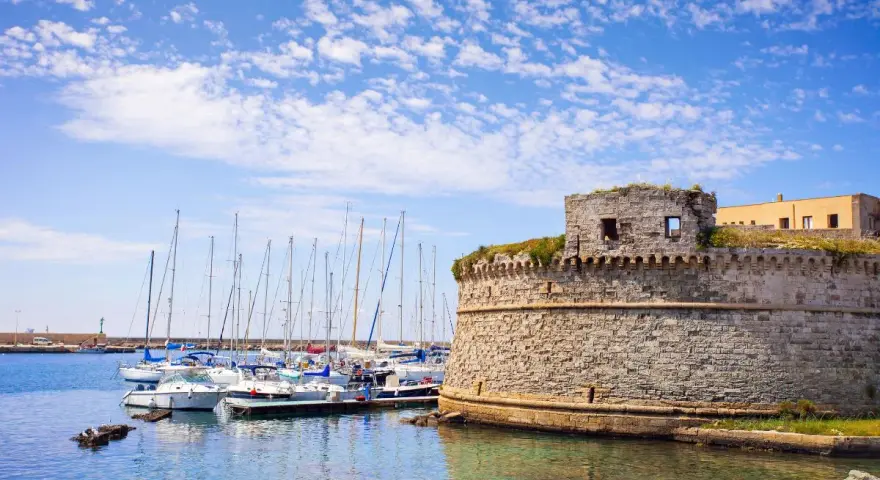 Porto di Gallipoli con castello e barche a vela. Un luogo incantevole per scoprire cosa fare a Gallipoli.