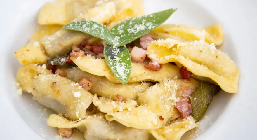 Casoncelli alla bergamasca, un classico su cosa mangiare a Bergamo, con pancetta, salvia e abbondante parmigiano.
