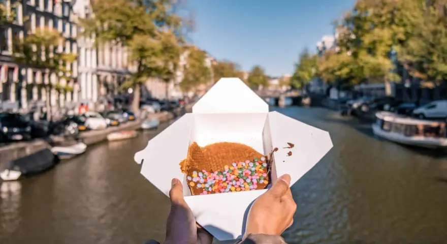 Un delizioso stroopwafel con zuccherini colorati, perfetto da gustare passeggiando lungo i canali di Amsterdam. Ecco cosa mangiare ad Amsterdam!