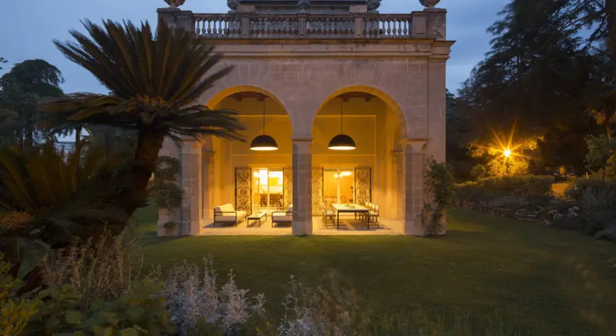 Villa Carrara a Genova, con portico illuminato e giardino serale.