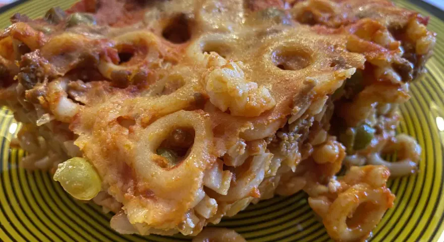 Un pezzo di pasta al forno con ragù e piselli, un'idea gustosa per cosa mangiare a Palermo.
