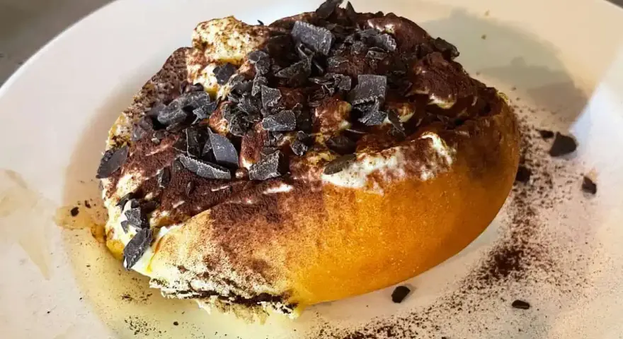 Un dolce al cucchiaio, forse un tiramisù rivisitato, con cacao e scaglie di cioccolato. Un'idea golosa su cosa mangiare a Roma.