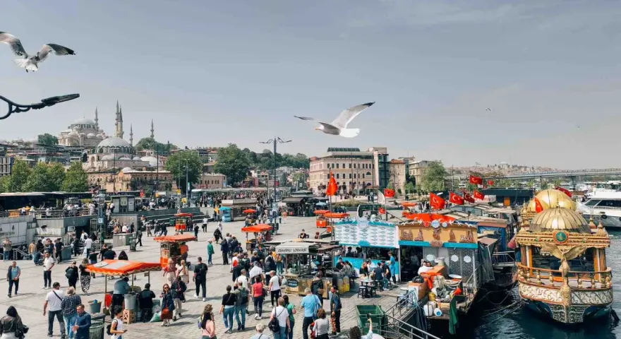 Un vivace mercato sul lungomare di Istanbul, con bancarelle di cibo, barche e la moschea sullo sfondo. Un momento perfetto per capire quando andare a Istanbul.
