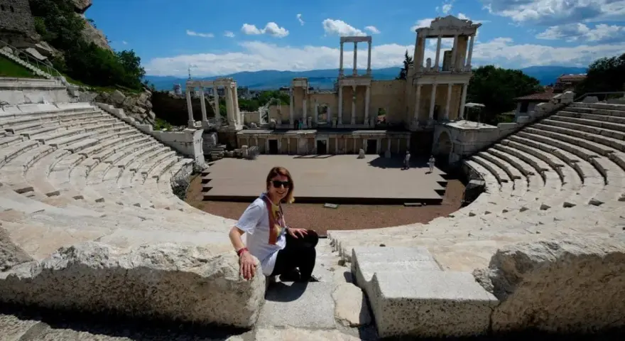 Donna sorride nell'antico teatro romano, un must per chi visita Plovdiv cosa vedere.