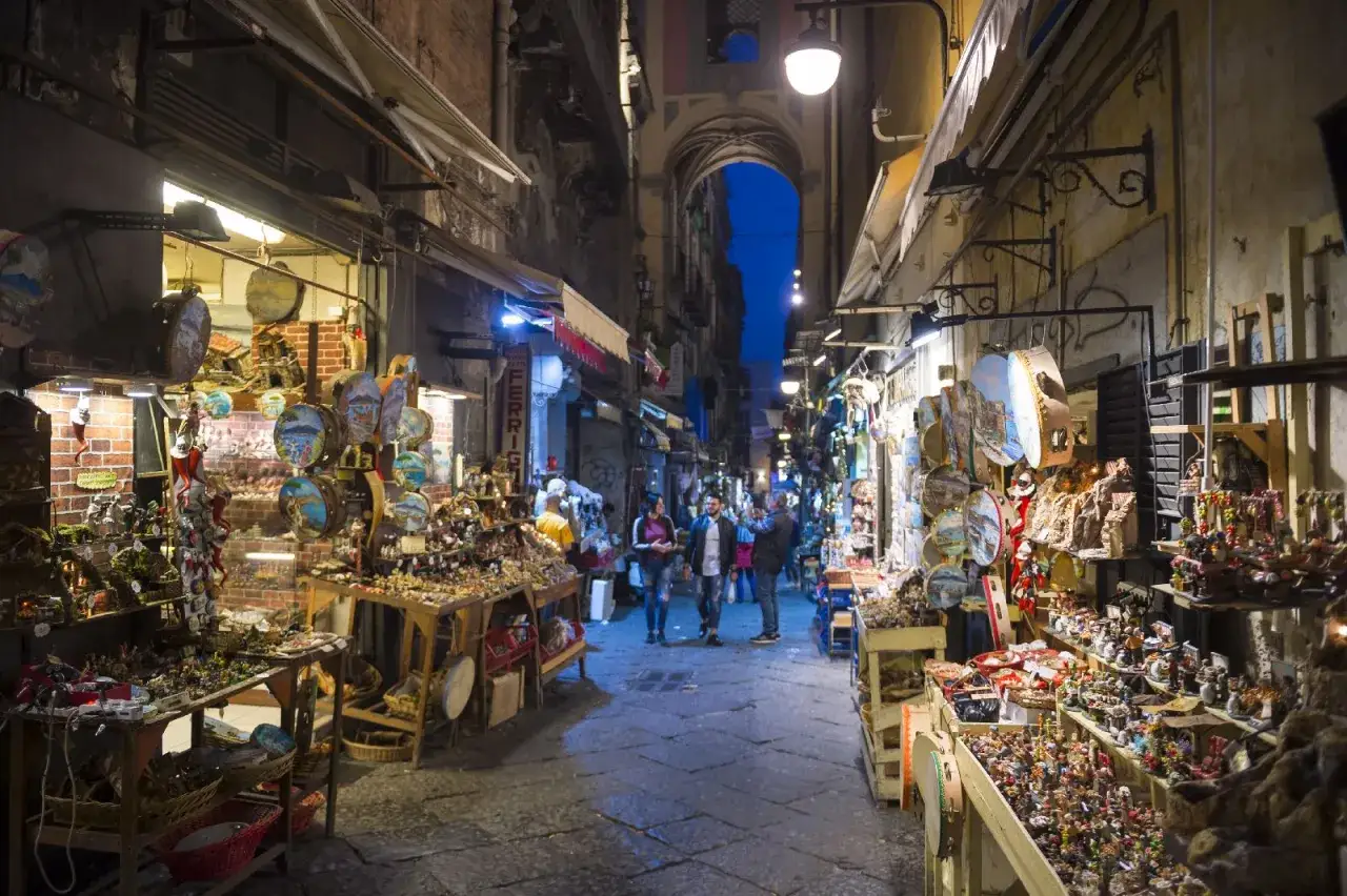 Mercatini napoletani, perfetti per un itinerario Napoli 3 giorni. Artigianato, presepi e souvenir illuminano la via.
